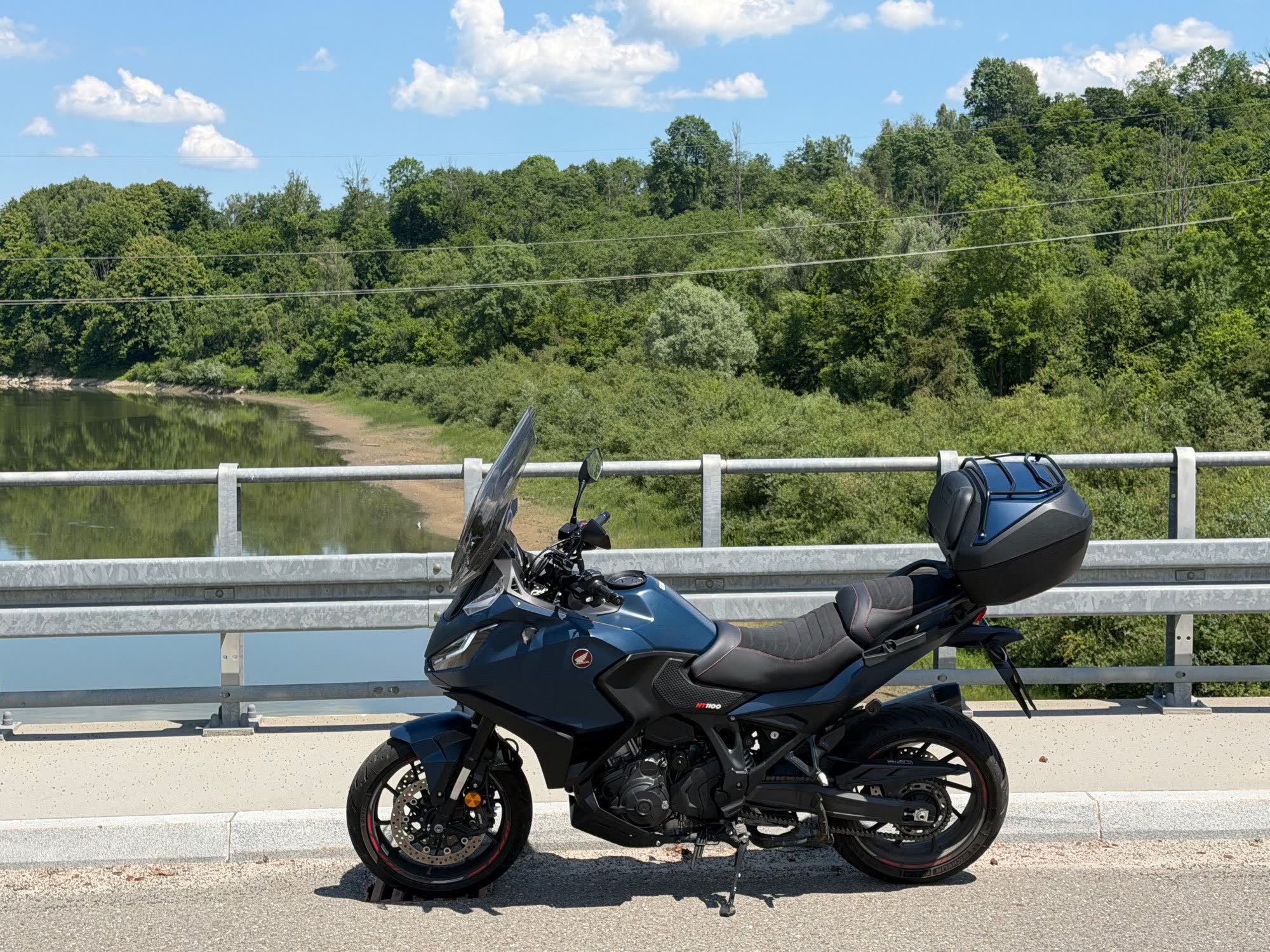 Honda NT1100 z boku, zaparkowana na moście nad rzeką w słoneczny dzień
